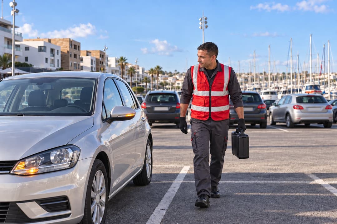 Salé : un dépanneur rejoint une voiture sur le parking de la marina, sa mallette à la main.