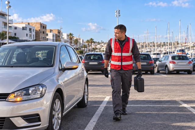 Salé : un dépanneur rejoint une voiture sur le parking de la marina, sa mallette à la main.